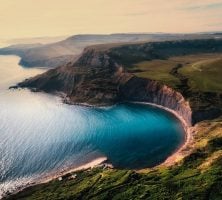 Cliffside Bay With Turquoise Water And Green Hills