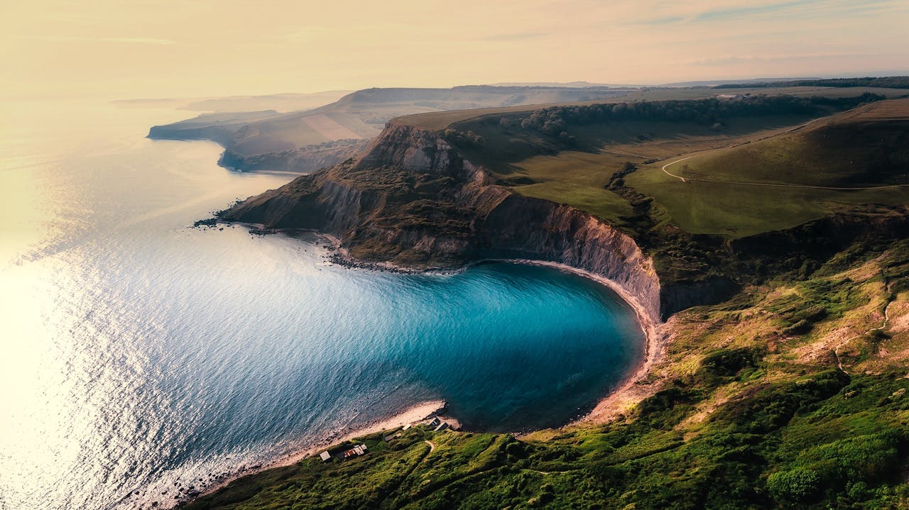 Cliffside Bay With Turquoise Water And Green Hills