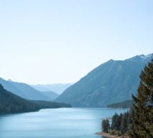 Blue Lake Surrounded By Pine-Covered Mountains