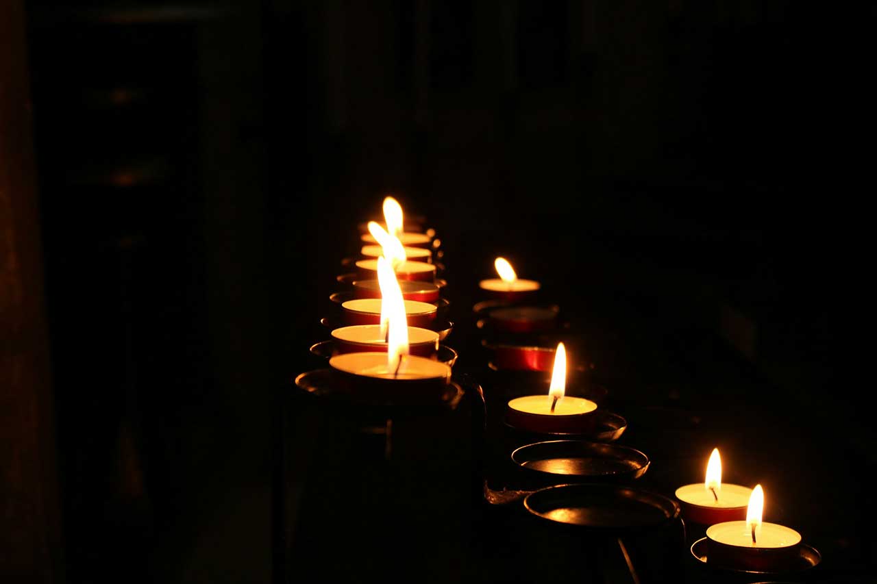 Lit Memorial Candles Glowing In A Dark Funeral Or Cremation Setting